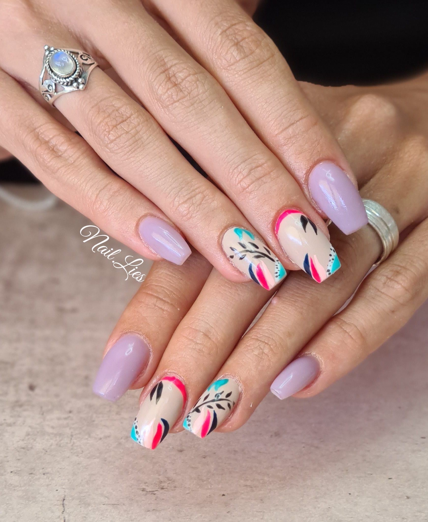 Lila nagels met kleurrijke abstracte lijnen op lichte accentnagels