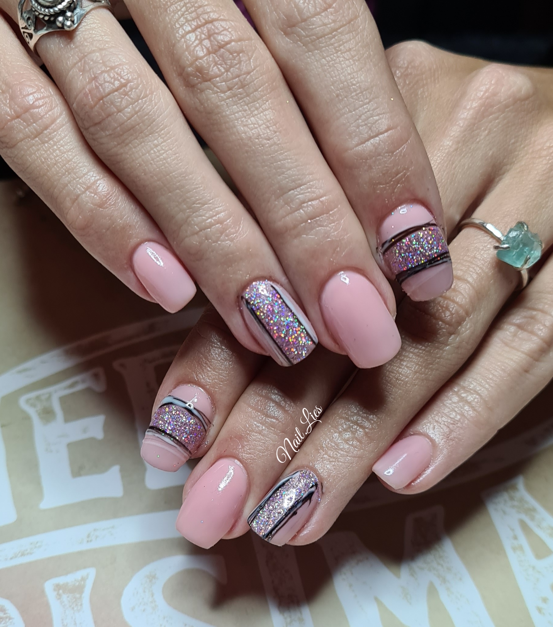 Zachtroze nagels met zilveren glitters en fijne donkere lijnen, gemaakt door Nail.Lies