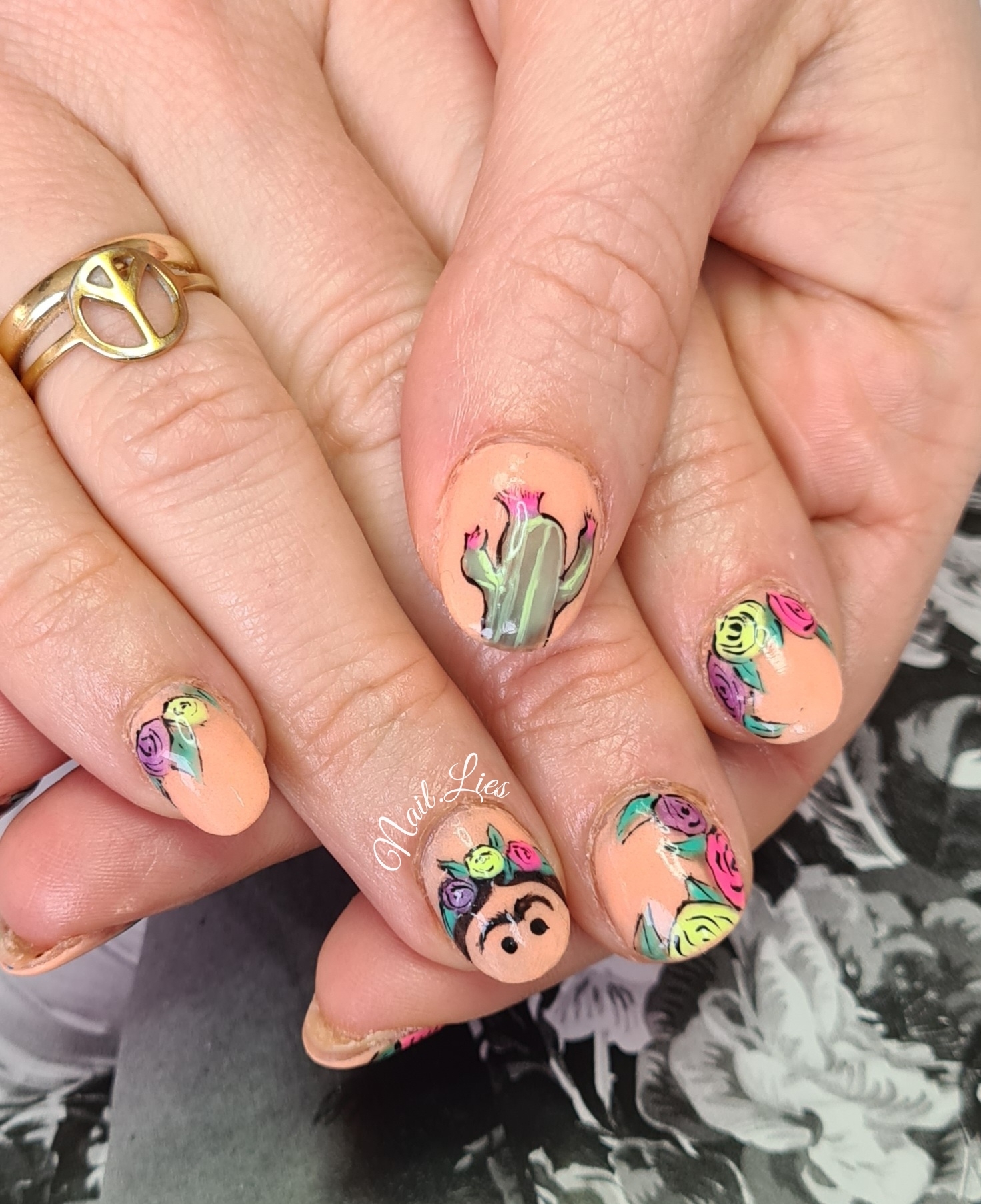 Nagels met handgetekende kleurrijke bloemen, een cactus en een gezichtje