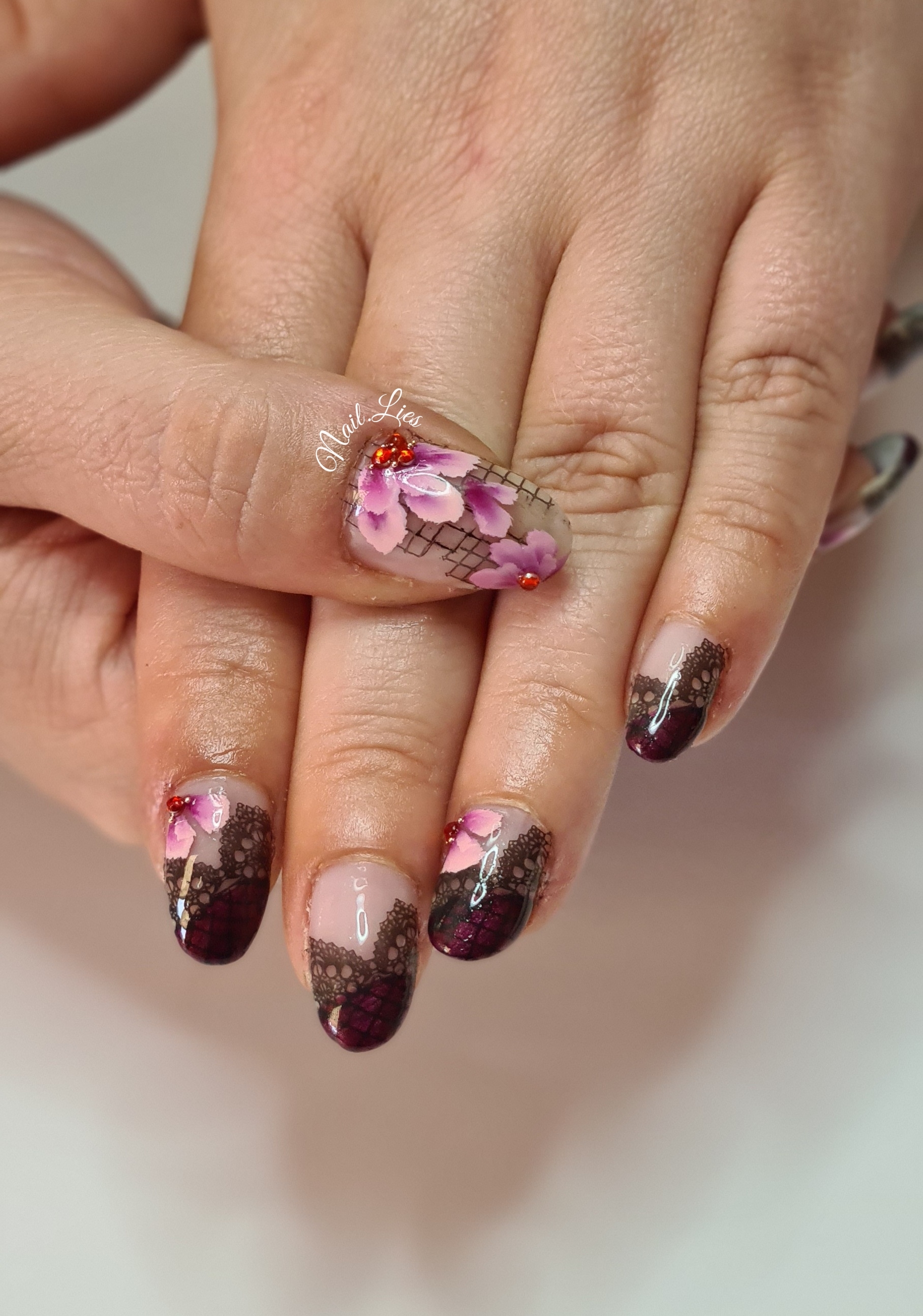 Lange puntige nagels met roze bloemen en donkere glitterpunten