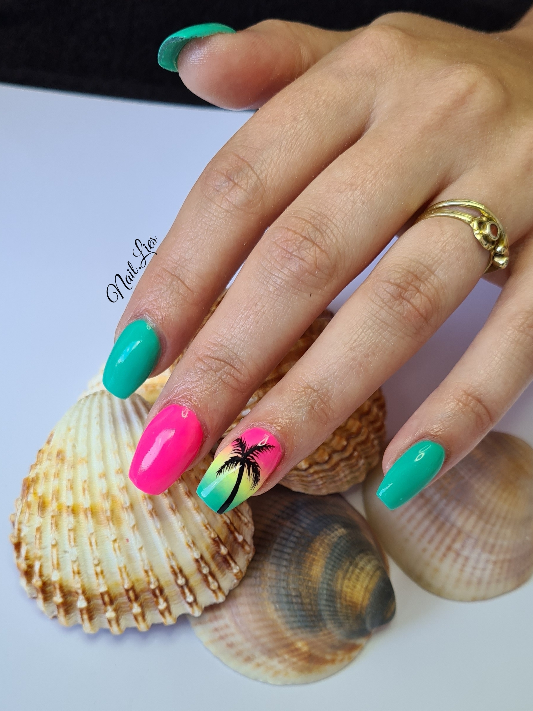 Felroze en groene nagels met een palmboom op een gele nagel